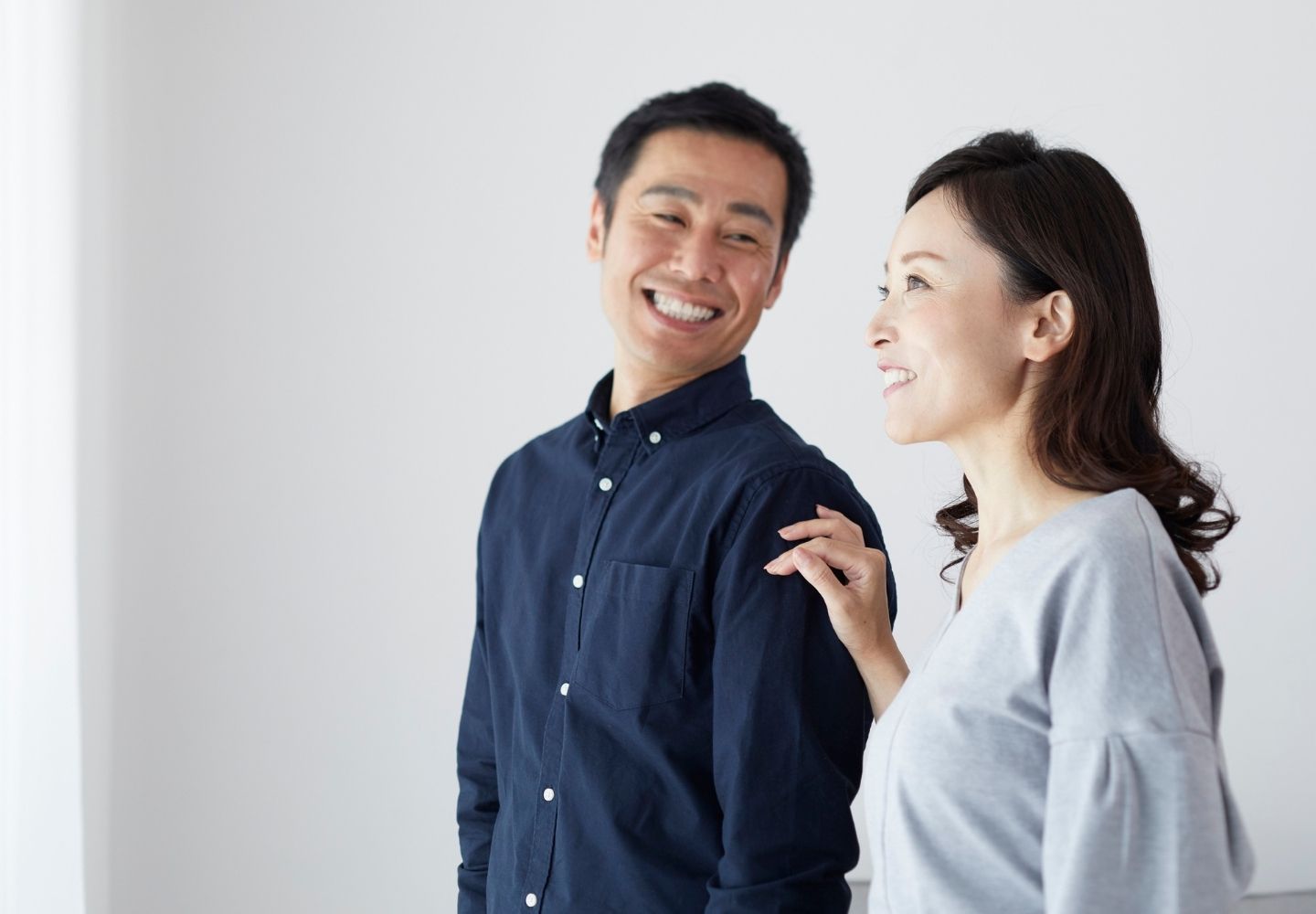 肩に手を添え笑い合う夫婦